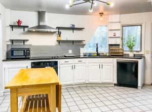 a kitchen with white cabinets and a table in it at Rocket City's Original Space Dome in Huntsville