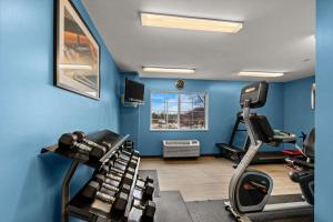 a gym with blue walls and a treadmill at Suburban Studios Sterling - Washington Dulles in Sterling