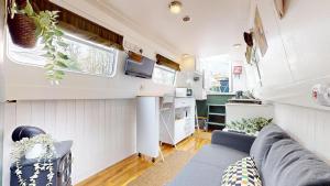 a living room with a couch and a kitchen at Executive houseboat in Little Venice in London