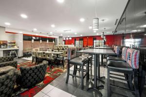 un restaurante con mesas, sillas y paredes rojas en Comfort Suites Williamsburg Historic Area, en Williamsburg