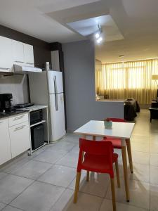 une cuisine avec une table blanche et des chaises rouges dans l'établissement Bonarda Mendoza, à Mendoza