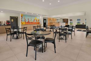 a restaurant with tables and chairs in a room at Quality Suites Lake Charles Downtown in Lake Charles