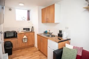 a small kitchen with a sink and a microwave at BV Homely Cozy Studio Apt Free Parking 10 Mins From Town Centre in Huddersfield