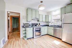 una cocina con armarios verdes y electrodomésticos de acero inoxidable en Close to Hospital Dining & Notre Dame, en South Bend