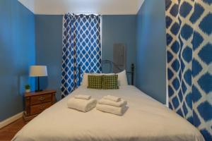 a bedroom with a large bed with towels on it at The Sunny Southern Manse Large Downtown Home in Columbus