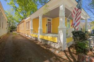 Uma casa amarela com uma bandeira americana. em The Sunny Southern Manse Large Downtown Home em Columbus