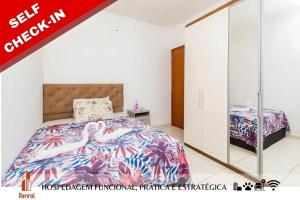 1 dormitorio con cama y espejo en Rental Palhoça- Acomodações Residenciais, en Palhoça