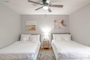two beds in a room with a ceiling fan at Parkhill Place- Mins from University of South AL in Mobile