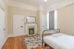 a bedroom with a bed and a fireplace at The Sunny Southern Manse Back Walk Downtown in Columbus