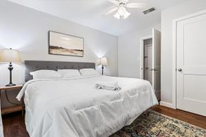 a white bedroom with a white bed and a ceiling fan at Close to Everything Dining Shopping & Hiking in Little Rock