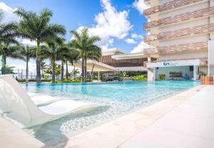 una piscina frente a un edificio con palmeras en Sonesta Ocean Point Resort- All Inclusive - Adults Only, en Maho Reef