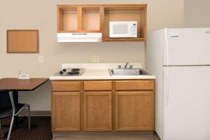 a kitchen with a sink and a white refrigerator at WoodSpring Suites Columbia Fort Jackson in Royal Pines Estates