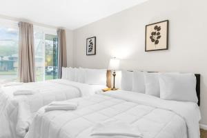 2 camas blancas en un dormitorio blanco con ventana en Fenced Yard Close to Hospital, en Birmingham