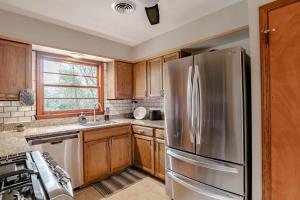 a kitchen with wooden cabinets and a stainless steel refrigerator at Wonderstruck on Wendover- 20 Mins to Downtown in Mobile