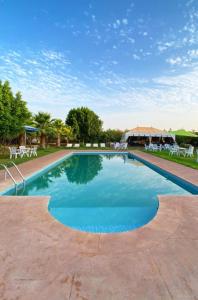 a large swimming pool with chairs and a building at Villa Baddi Marrakech in Marrakesh