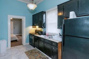 a kitchen with black cabinets and a black refrigerator at Banks of the Chattahoochee Cottage Walk to Dining in Columbus