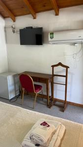 een kamer met een bureau, een stoel en een televisie bij Hostería Don Costa in Chos Malal