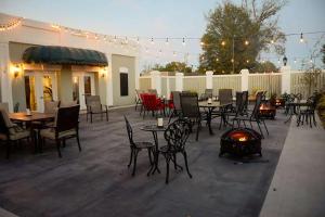 a patio with tables and chairs and a fire pit at Inn on the Square, Ascend Hotel Collection in Greenwood