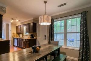 a kitchen with a wooden table and a large window at Minutes to Benning Two-Story Oasis Benning Bliss in Columbus