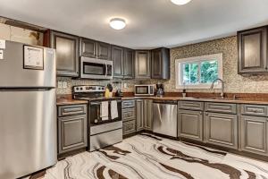 a kitchen with stainless steel appliances and wooden cabinets at Sweet Sunny Retreat- Main House in Savannah
