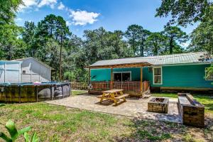 een klein blauw huis met een picknicktafel en een grill bij Sweet Sunny Retreat- Both Houses in Savannah