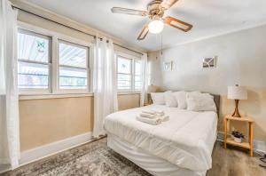 um quarto com uma cama branca e uma ventoinha de tecto em Near Shopping & Dining- Magic in Midtown- Unit A em Memphis
