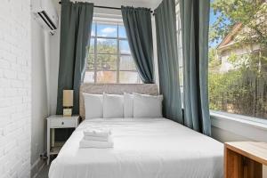 een slaapkamer met een wit bed en een raam bij Near University & Dining- Garden District Dwelling in Montgomery