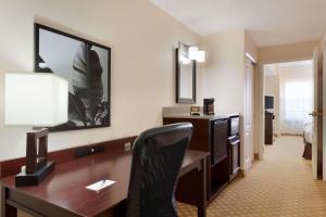 a hotel room with a desk and a chair at Country Inn & Suites by Radisson, St Augustine Downtown Historic District, FL in Saint Augustine