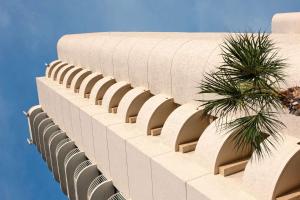 a building with a palm tree on the side of it at Radisson Suite Hotel Oceanfront in Melbourne
