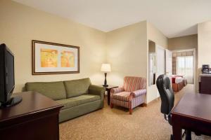 sala de estar con sofá y dormitorio en Country Inn & Suites by Radisson, Albany, GA, en Albany