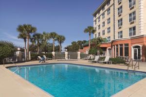 a large swimming pool in front of a building at Country Inn & Suites by Radisson, Orlando Airport, FL in Orlando