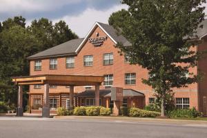 a red brick building with a sign on it at Country Inn & Suites by Radisson, Newnan, GA in Newnan