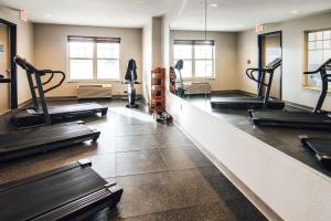 einen Fitnessraum mit mehreren Laufbändern und Kardiogeräten in der Unterkunft Country Inn & Suites by Radisson, Stockton, IL in Stockton