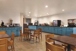 una cocina con armarios azules y mesas y sillas de madera en Country Inn & Suites by Radisson, Georgetown, KY, en Georgetown