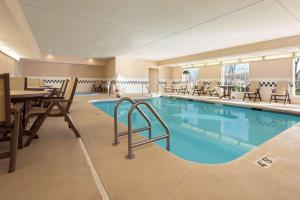 a pool in a hotel room with tables and chairs at Country Inn & Suites by Radisson, Clinton, IA in Clinton +35 photos