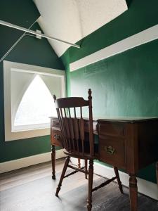 a room with a desk and a green wall at Evansville Holiday House in Evansville