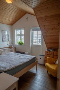 a bedroom with a large bed and two windows at Akureyri Old Town Home in Akureyri