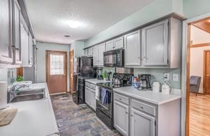 a kitchen with white cabinets and white counter tops at Near Shelby Farms & Greenline- Cordova Comfort in Memphis
