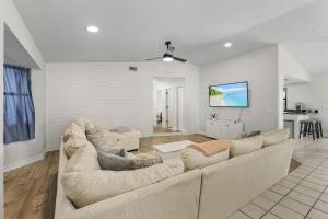 uma sala de estar com um sofá grande e uma mesa em Palmetto Pines Paradise em Cape Coral