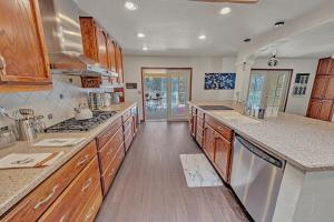 a large kitchen with wooden cabinets and wooden floors at NEW! Spacious, Full Game Room, Ping Pong, Yoga, Golf Course, Pickle Ball! in Sedona