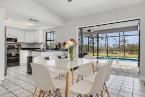 a kitchen and dining room with a table and chairs at Palmetto Pines Paradise in Cape Coral