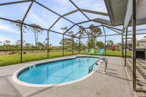 an indoor swimming pool with a clear glass roof at Palmetto Pines Paradise in Cape Coral