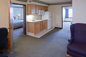 a kitchen with a sink and a refrigerator in a room at Country Inn & Suites by Radisson, Lansing, MI in Lansing