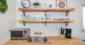 cocina con fregadero y microondas en Columbus First Tiny House Amenities & Charm en Columbus