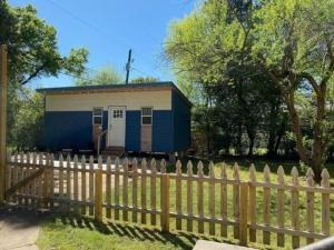 a blue and white tiny house behind a fence at Columbus First Tiny House Amenities & Charm in Columbus