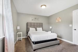 a bedroom with a large white bed with two lamps at Mins to Oakwood U! American Retreat in Huntsville