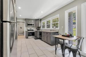 a kitchen with a table and a refrigerator at Mins to Oakwood U! American Retreat in Huntsville