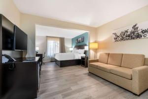 a hotel room with a bed and a couch at Sleep Inn & Suites in Newport News