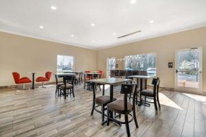 uma sala de jantar com mesas, cadeiras e janelas em Sleep Inn & Suites em Newport News