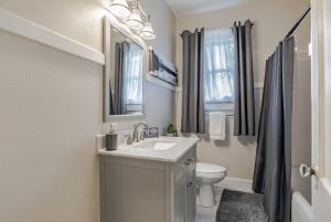 un bagno bianco con lavandino e WC di Haute on Hannon- Midtown Cottage! a Mobile Altre 62 foto